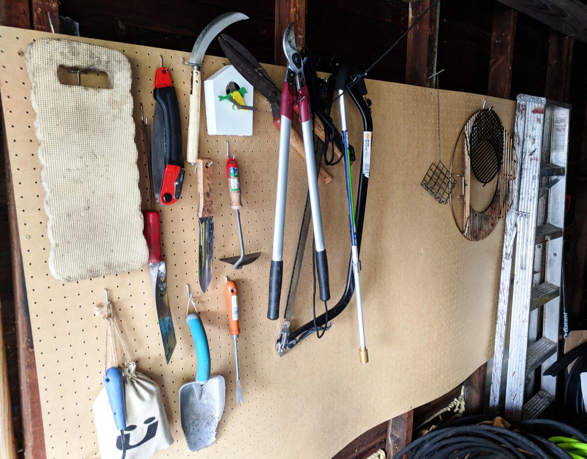 Pegboard garden implements on pegs