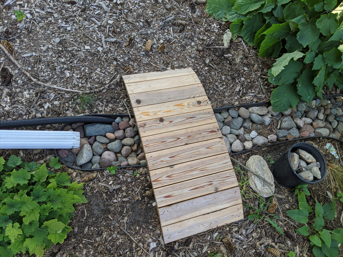 Finished channel filled with rocks and small footbridge